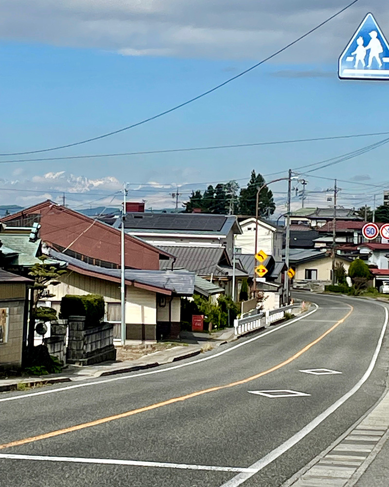 遠くに雪をかぶった山脈が見える写真